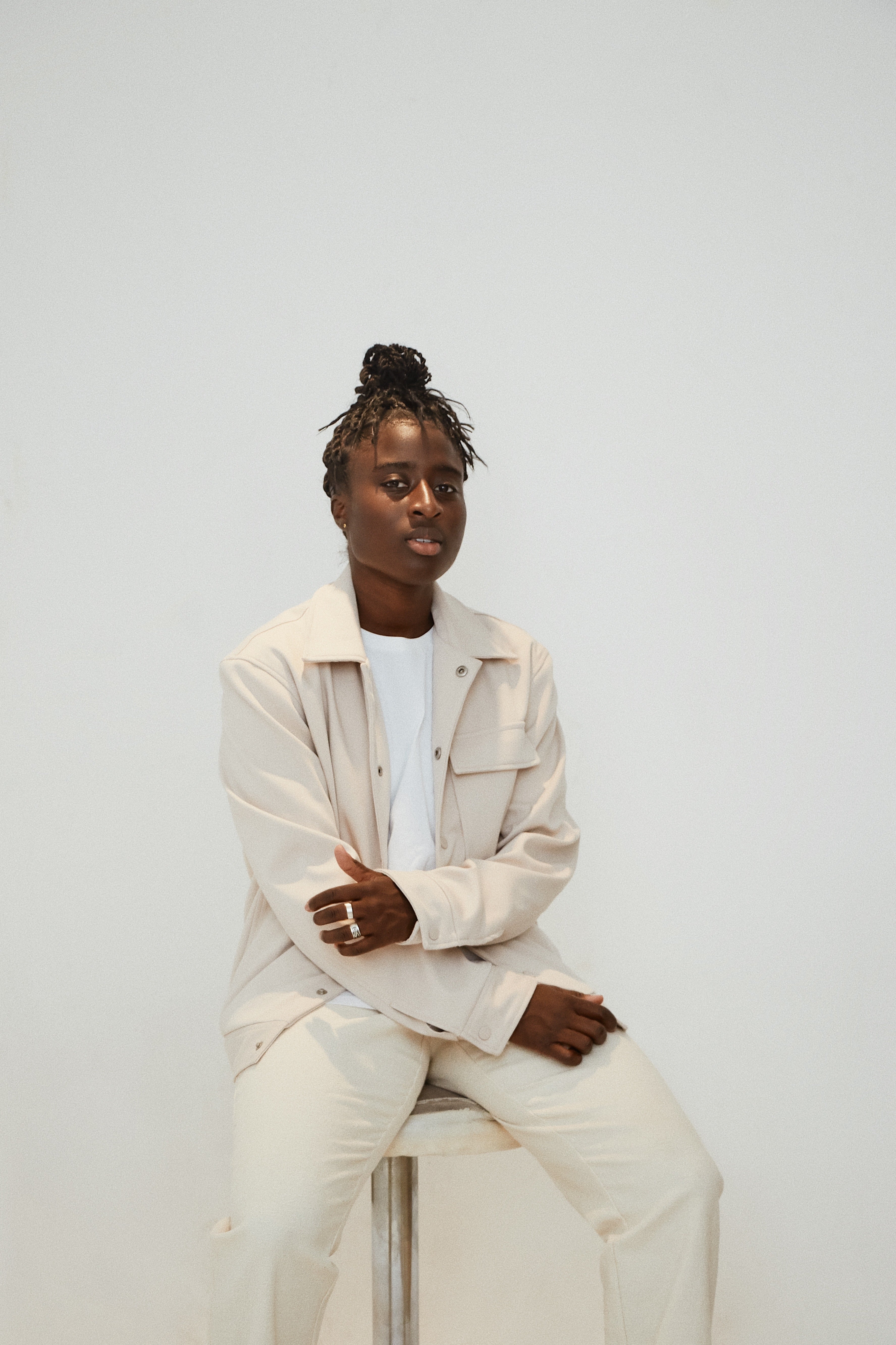 EUNICE in a cream outfit against a white background